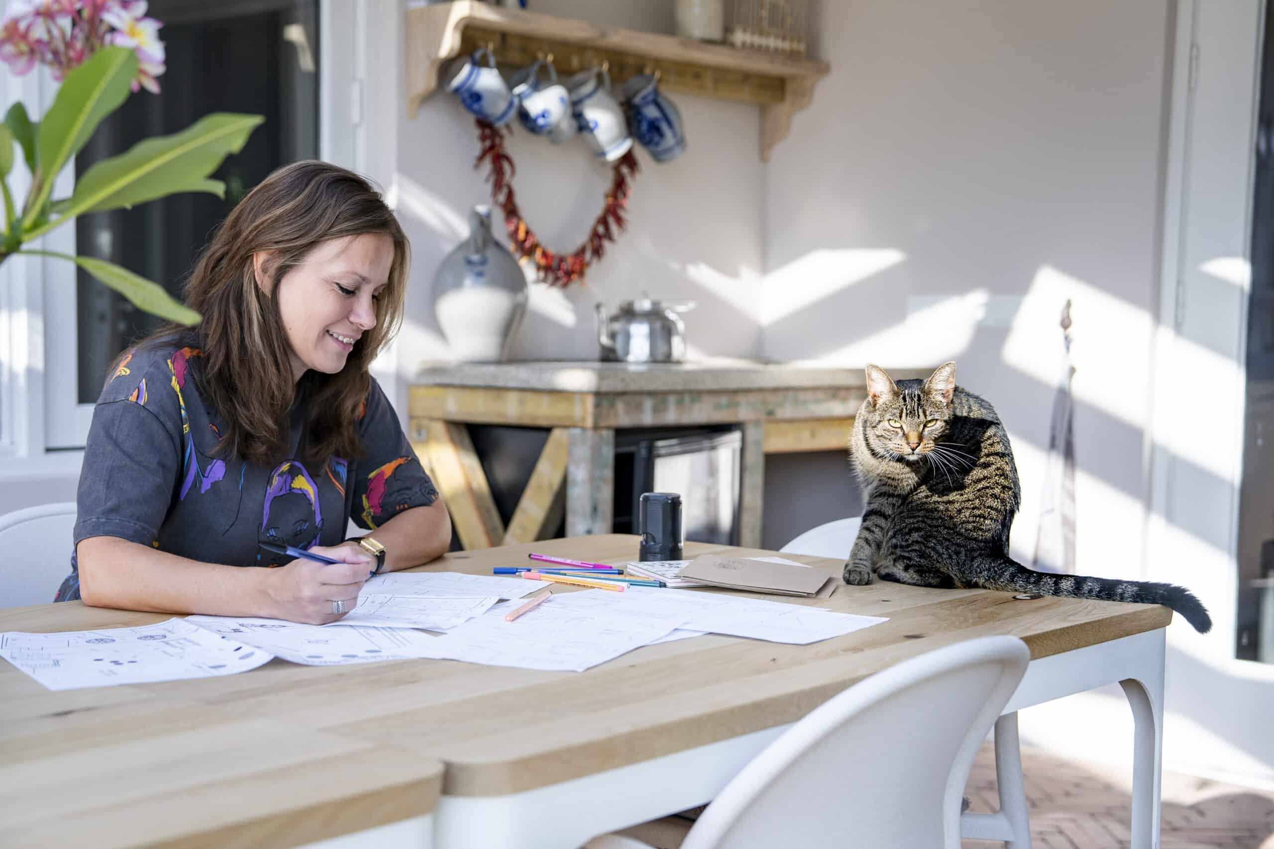 Linsey aan het werk voor een moestuin ontwerp in de orangerie met haar kat