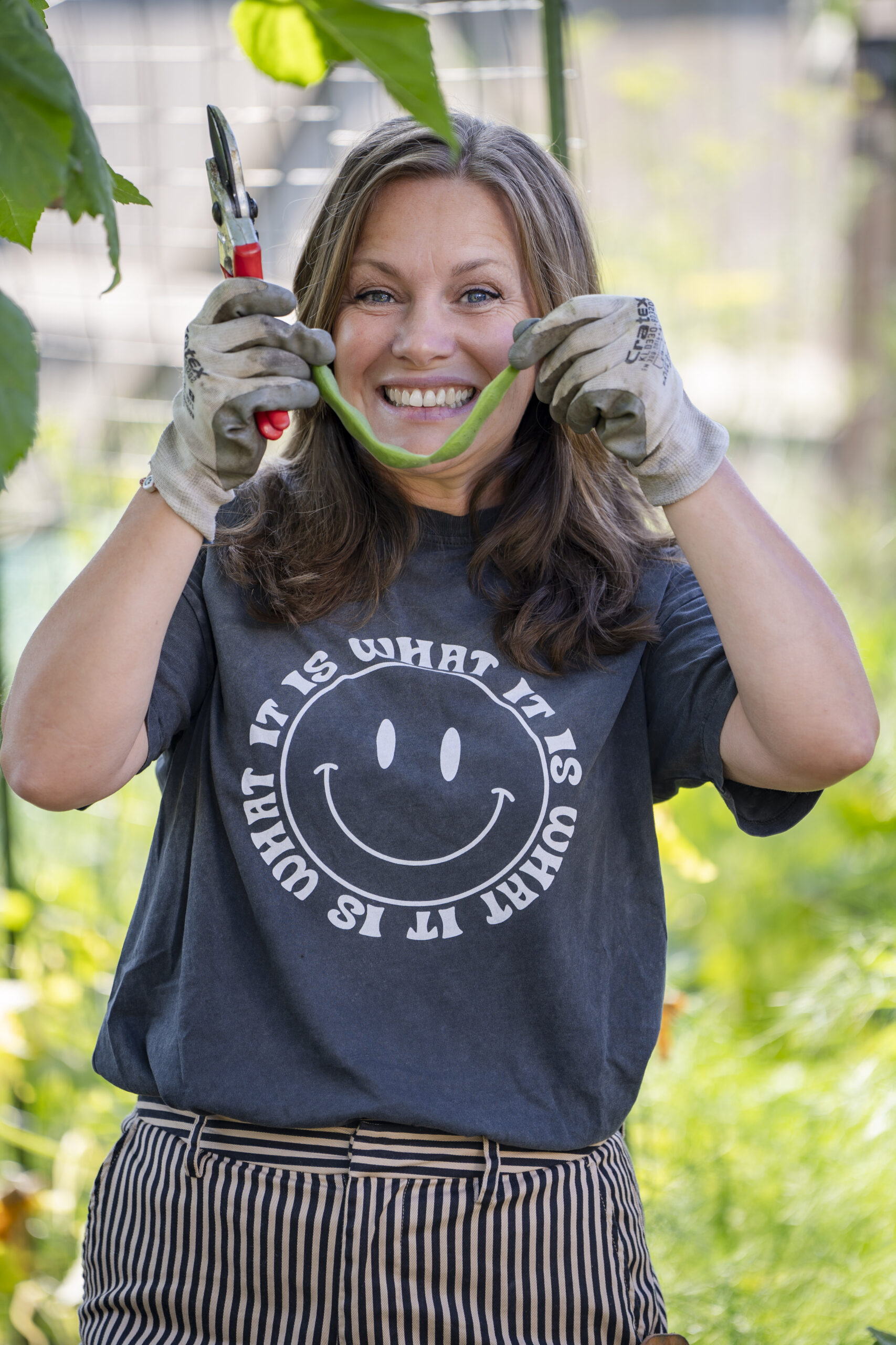 Linsey is helemaal blij met een boon die gekweekt is in haar eigen moestuin