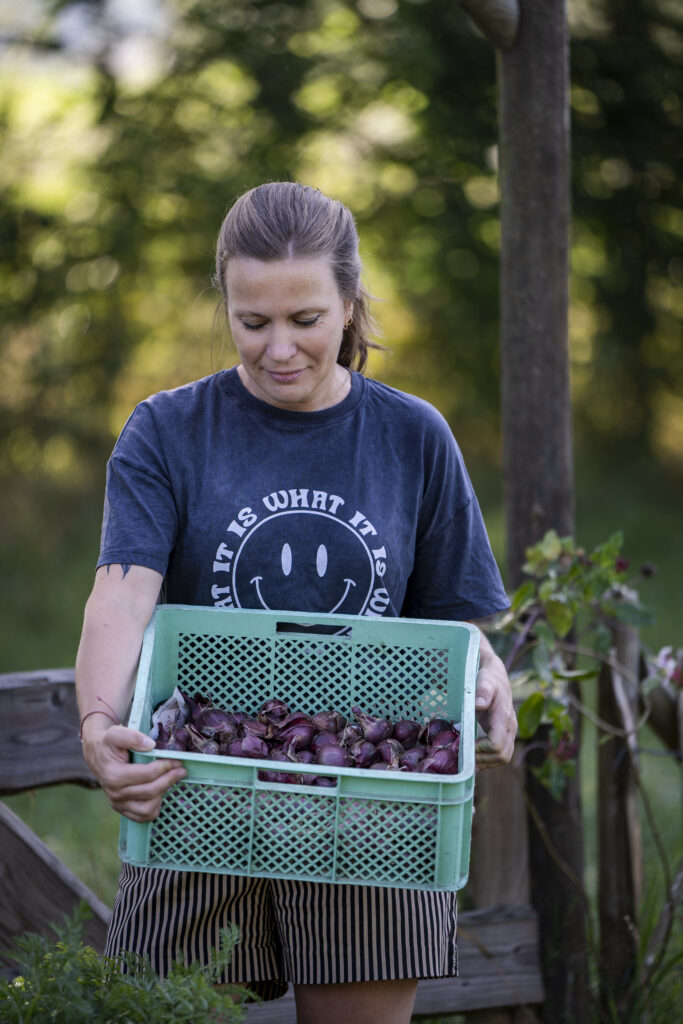 Linsey met een bak vol eigen gekweekte uien uit haar eigen moestuin