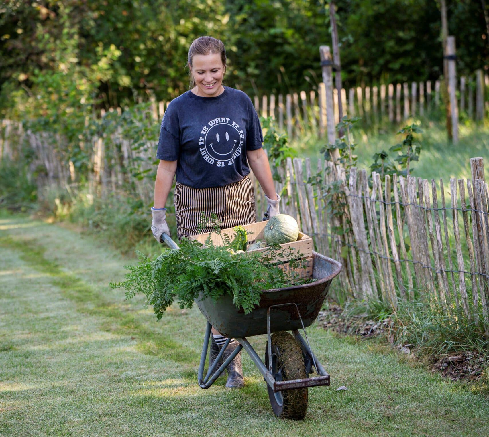 Linsey van Foxhill loopt door de tuin met een grote kruiwagen vol verse groenten